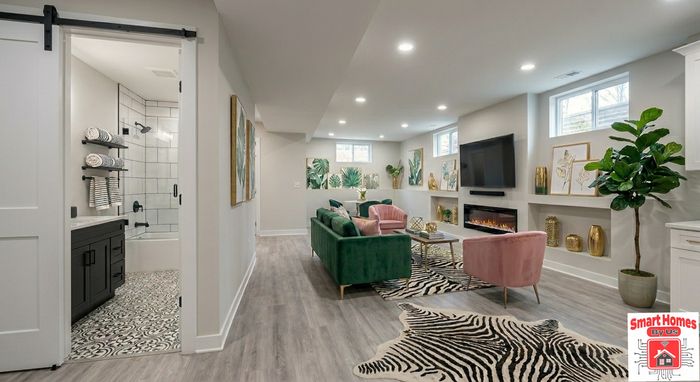 Living area with an electric fireplace, built-in niches and a full bathroom behind a barn door