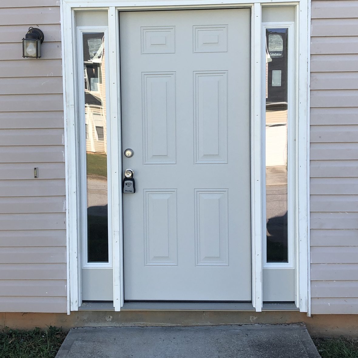 After: the same entry with a new door, frame and sidelights