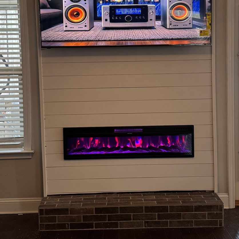 After: the same wall covered in shiplap with an electric fireplace and the TV mounted above