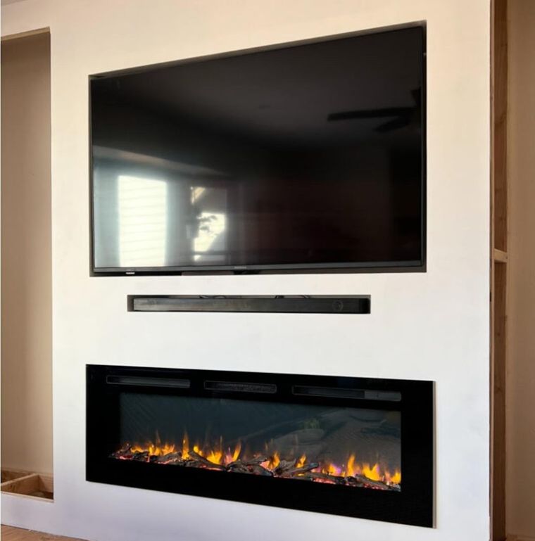Recessed TV and electric fireplace built into a new drywall feature wall