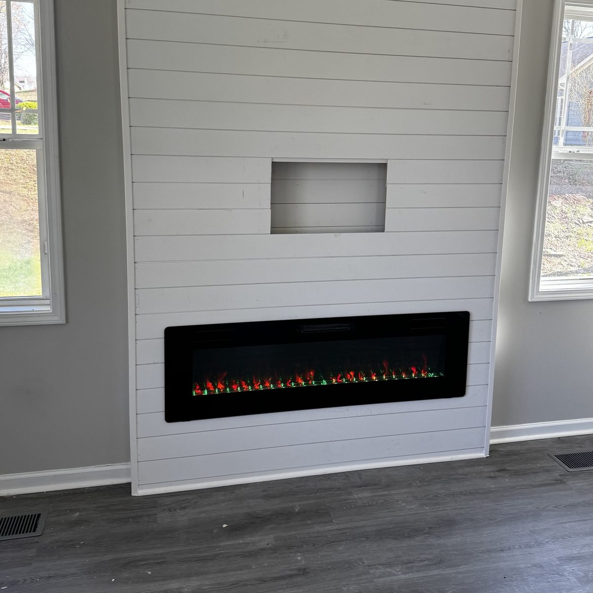 After: the same surround finished in shiplap with an electric fireplace and a TV niche