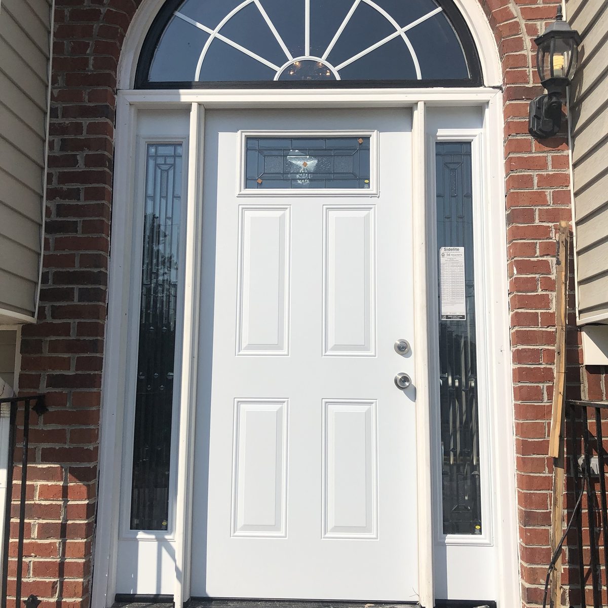 After: the same entry with a new white door and glass sidelights