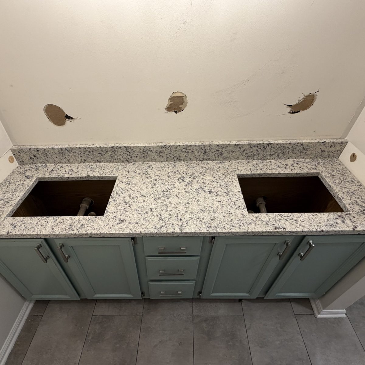 Before: a granite vanity top with open sink cutouts